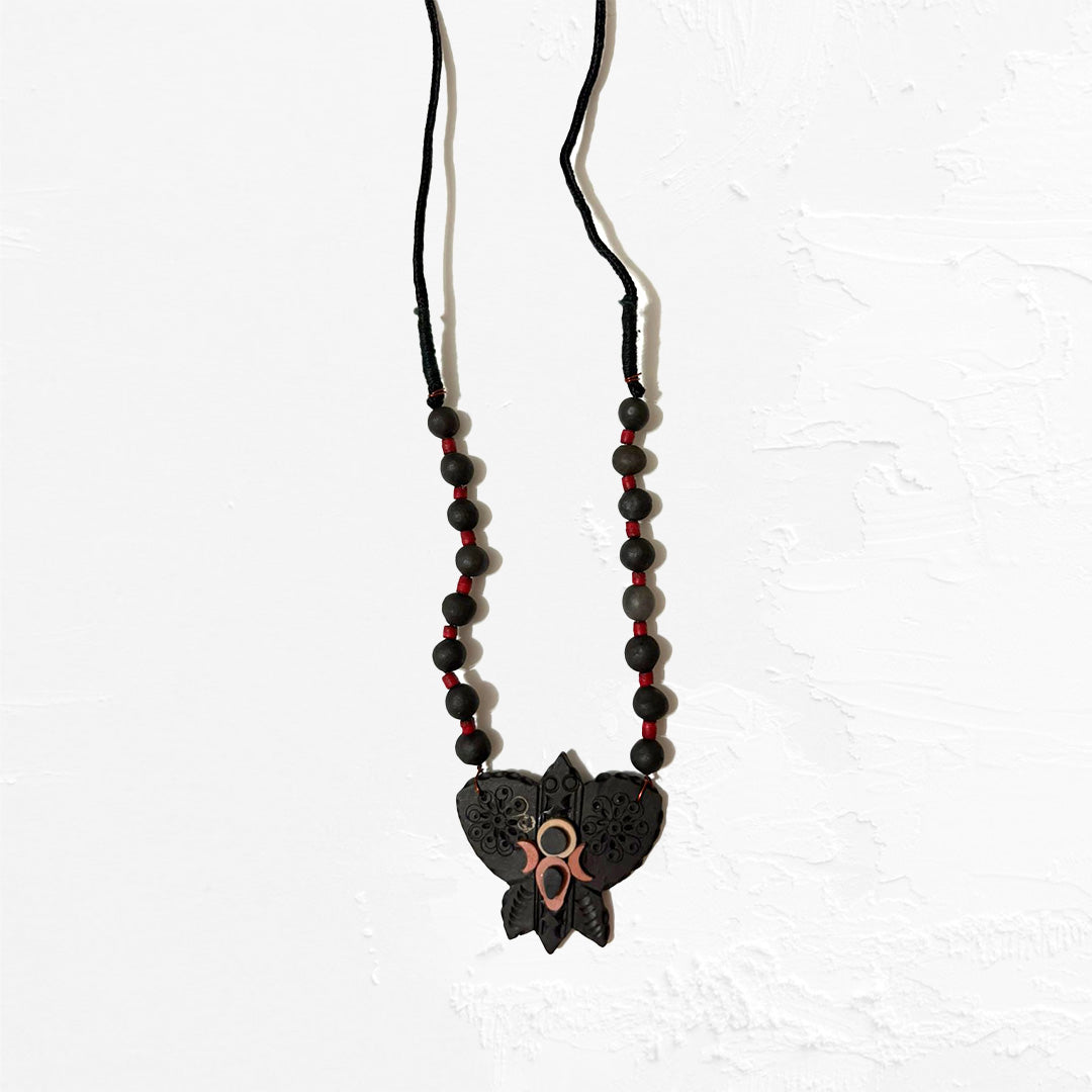 Necklace with black and red beads and a butterfly pendant on a white background