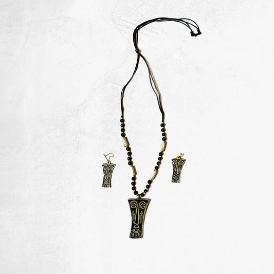 Tribal mask pendant necklace and earring set with black beads and gold-tone accents on a white background